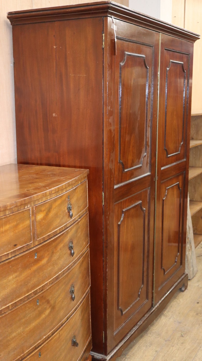A Georgian style mahogany wardrobe fitted a pair of panelled doors, W.129cm, D.57cm, H.108cm